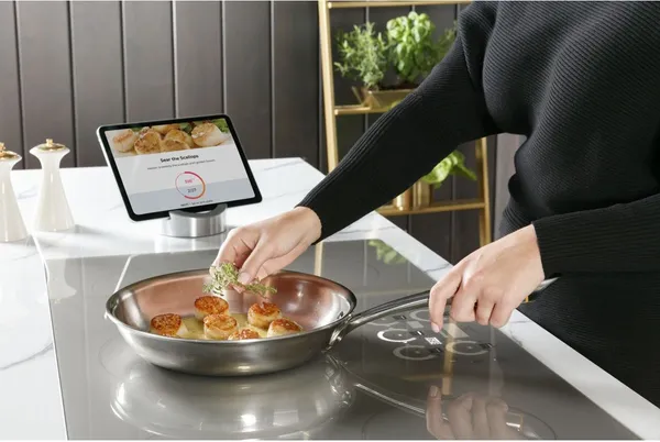 A person preparing scallops on the Monogram ZHU36RSTSS induction cooktop